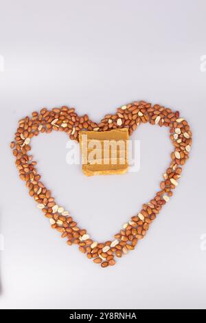 Homemade peanut butter and patterned sandwich isolated on white background. The concept of love for nuts. Favorite breakfast. Nuts in the shape of a Stock Photo