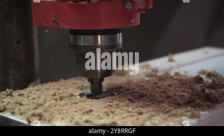 Milling the hole in wood. Worker with milling cutter in action. Countersink drill bit make sink in hole. Man uses drilling machine to make a hole on w Stock Photo