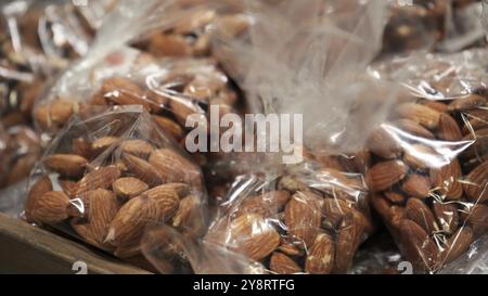 Arachis inside packaged plastic in a grocery store. Packaging from different types of nuts on the window window. Large plan, snack, concept of healthy Stock Photo