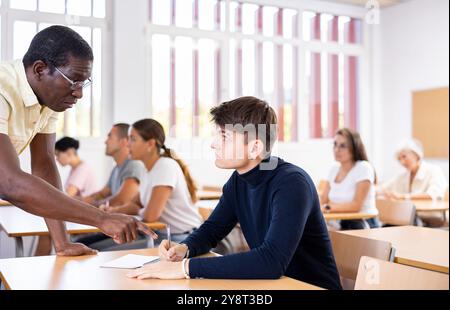 African American teacher helping student solve task during lesson Stock Photo