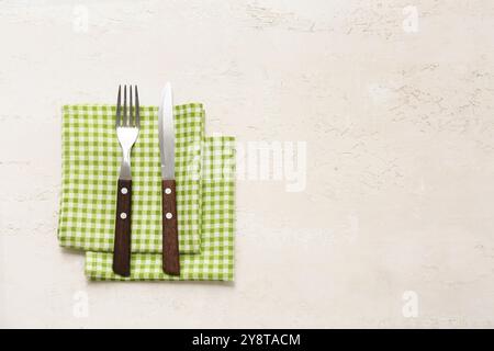 Table setting with checkered napkins and stylish cutlery on beige background Stock Photo