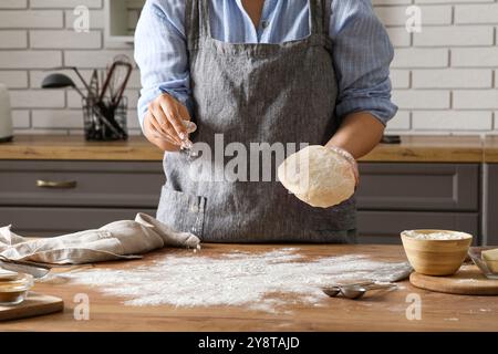 Woman preparing traditional cinnamon rolls in kitchen Stock Photo