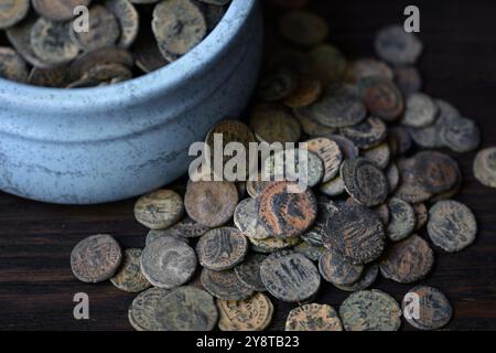 Many Roman coins on old dark wooden table, Ancient money hoard, vintage background. Concept of pile, antique, Empire, texture, civilization and histor Stock Photo