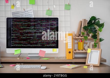 Computer monitor with code and sticky notes on programmer's desk in office Stock Photo