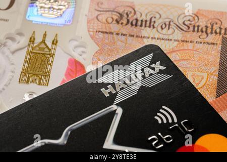Halifax credit card and British currency close-up. Financial concept featuring credit services, digital banking, and modern payment solutions. Staffor Stock Photo