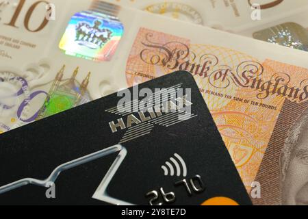 Halifax debit card close-up with British currency. Emphasizing secure digital banking, financial services, and modern payment solutions. Stafford, Uni Stock Photo