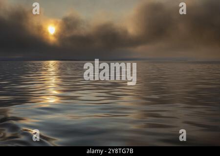 Sun breaking through clouds, reflection on slightly wavy sea surface, Woodfjord, Svalbard and Jan Mayen archipelago, Norway, Europe Stock Photo