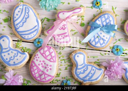 Homemade Easter cookies in shape of eggs chicken and rabbit on white wooden kitchen table flat lay closeup view. Space for text Stock Photo