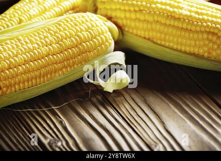 Ripe fresh organic sweet corncobs on wooden table Stock Photo