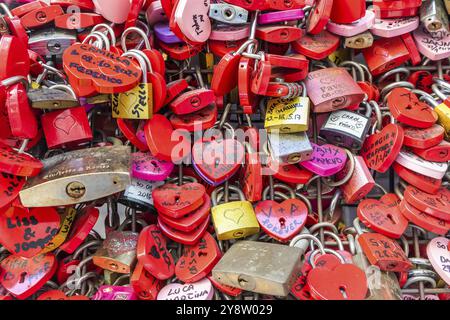 Verona, Italy, June 2022: background of heart-shaped locks on a wall, symbol of love forever, Europe Stock Photo