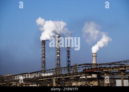 Smoke stack over chemical plant on blue sky background Stock Photo