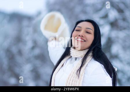 Cheerful woman with beanie in snowy nature Stock Photo
