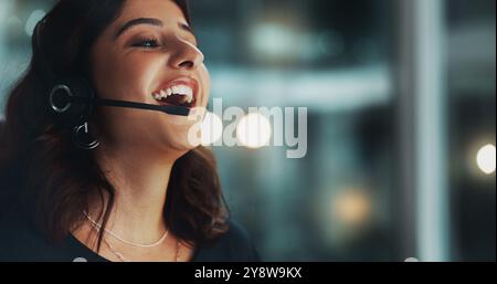 Call center, happy and woman in office at night for international technical support consultation online. Headset, audio tech and customer service Stock Photo