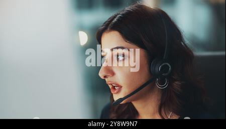 Call center, computer and woman in office at night for international technical support consultation online. Headset, tech and customer service agent Stock Photo