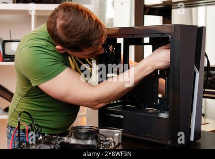 Man assembles a computer system unit at home Stock Photo