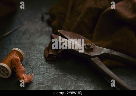 Still life composed from tailor's old tools and accessories such as scissors, measuring tape, leather fabric, sewing box in scene. Sewing supplies in Stock Photo