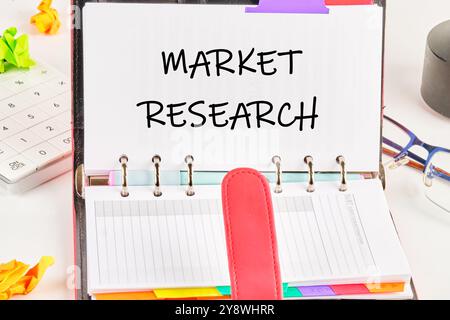 The concept of the info business. The text of MARKET RESEARCH is written on a blank page of an open business notebook. Stock Photo