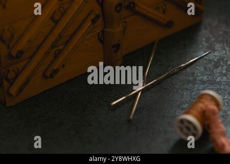 Still life composed from tailor's old tools and accessories such as scissors, measuring tape, leather fabric, sewing box in scene. Sewing supplies in Stock Photo