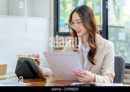 Happy young business woman working on her project at the office alone Stock Photo
