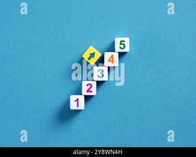 Step by step concept. Career development, accomplishing the necessary steps. Five numbered cubes arranged in ascending order forming upward steps with Stock Photo