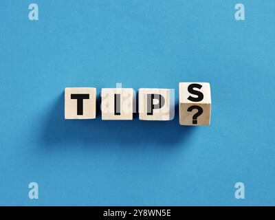 Helpful tips concept emphasizing advice and guidance. Question about tips being asked with letter cubes forming the word tips with a question mark on Stock Photo