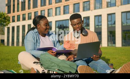 African American gen z student girl woman help guy man with online task explain homework friends together discuss project computer learning study Stock Photo