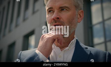 Caucasian senior pensive thinking mature businessman smartphone using mobile application mature thoughtful business man looking at cell phone working Stock Photo