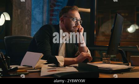 Tired lazy man male manager business bored work online computer in dark night office Caucasian mature stressed exhausted fatigued businessman need Stock Photo