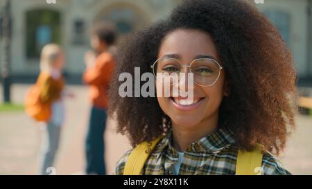 Portrait African American happy smiling healthy teeth eyesight in glasses woman girl female student looking at camera outside of college university Stock Photo