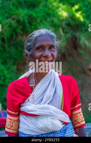 Happy smiling gap-toothed wiry-haired Sri Lankan lady in sore need of a good dentist, begging at Rawana (aka Ruwana, Ravana) Ella Falls, Sri Lanka Stock Photo