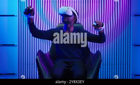 African American man guy male gamer gaming vr play wearing virtual reality glasses helmet three dimension game modern cyber technology neon futurism Stock Photo