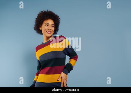 A young woman expresses joy and confidence, radiating emotion in a vibrant, patterned sweater. Stock Photo