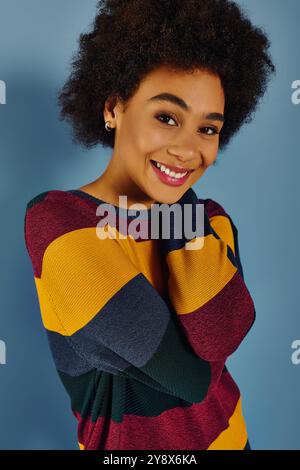 A young woman with a bright smile radiates positivity while embracing herself warmly. Stock Photo