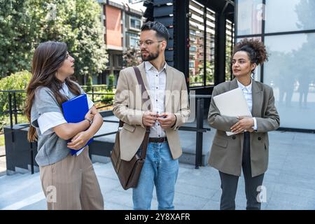 Group of young businesspeople stock market and exchange experts, leaders in modern science, finance and economy standing outside of office building. S Stock Photo