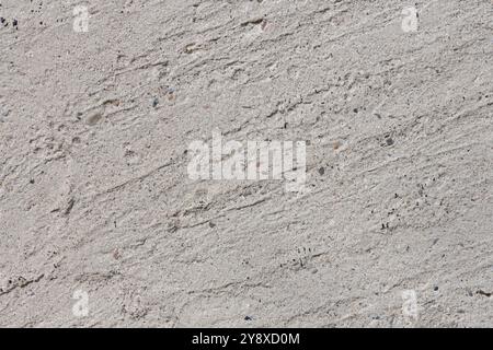 Concrete texture with slight surface irregularities. Monolithic concrete wall or floor with sand and fine pebbles on surface, high resolution. Stock Photo