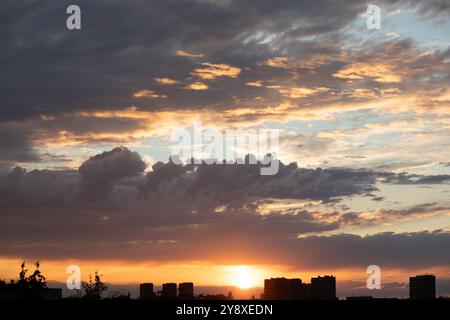 Sunrise sky above a city. Incredible natural colors. Red, orange, blue. Heaven. Stock Photo