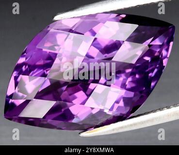 A Dazzling Large Purple Amethyst Gemstone Reflecting Light Elegantly. Stock Photo