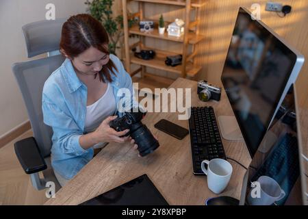 A female photographer is editing photos on her computer at home. Stock Photo