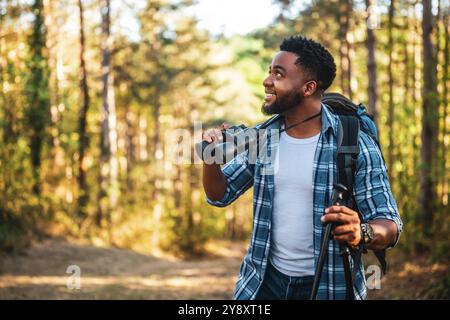 Young man enjoys using binoculars and hiking in nature. Stock Photo