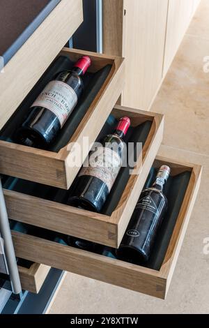 Red wine storage in designer kitchen, Gloucestershire, England, UK Stock Photo