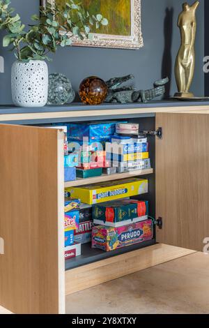 Games storage cupboard in family home, Gloucestershire, England, UK Stock Photo