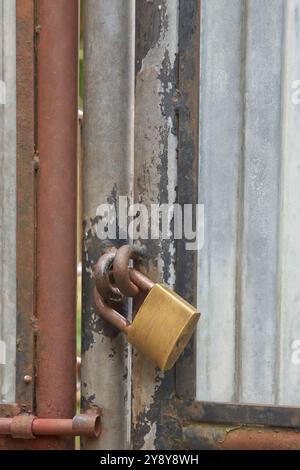 old padlock on rusty metal gate with peeling paint background, soft focus with copy space Stock Photo