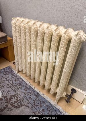 Classic metallic radiator installed in a cozy indoor space with exposed ...