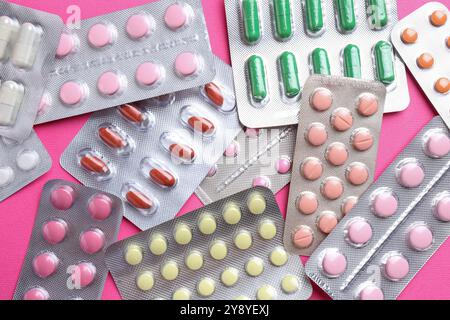 Pharmacist concept. Flat lay composition with many different pills on pink background Stock Photo