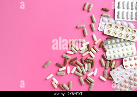 Pharmacist concept. Flat lay composition with many different pills on pink background, space for text Stock Photo