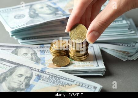 Woman stacking coins at grey table, closeup Stock Photo