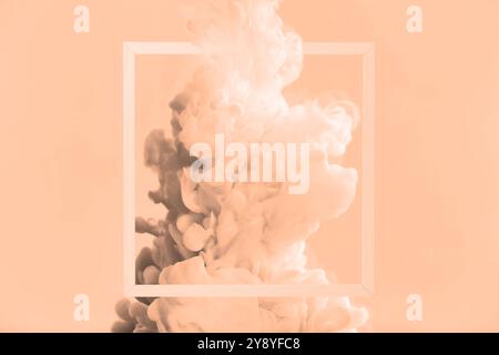 Splash of ink and frame on peach fuzz color background Stock Photo