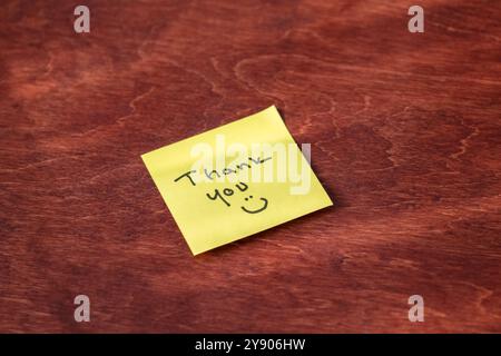 Yellow Sticky Note with Handwritten “Thank You” and Smiley Face – Expressing Gratitude and Appreciation in a Fun, Personal Way, Perfect for Office or Stock Photo