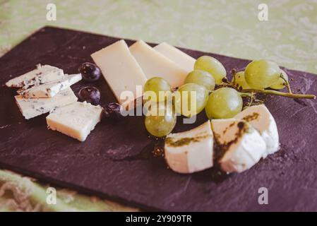 A Table of cheese slices is the perfect end to a typical meal, a gorgeous aperitif or a very rich snack. Stock Photo