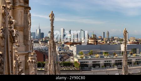 A picture of the Duomo di Milano or Milan Cathedral roof spires and statues overlooking the Porta Nuova business district. Stock Photo